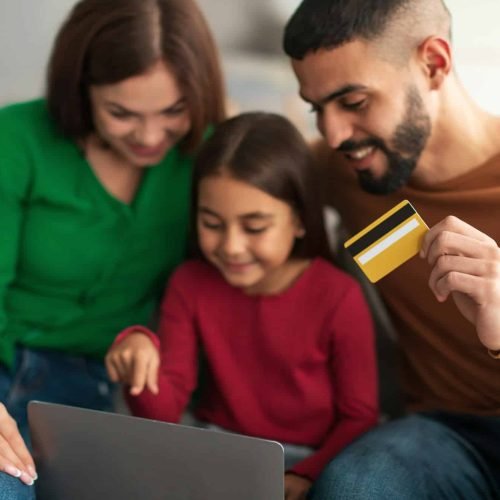 Arabic family using computer and credit card at home